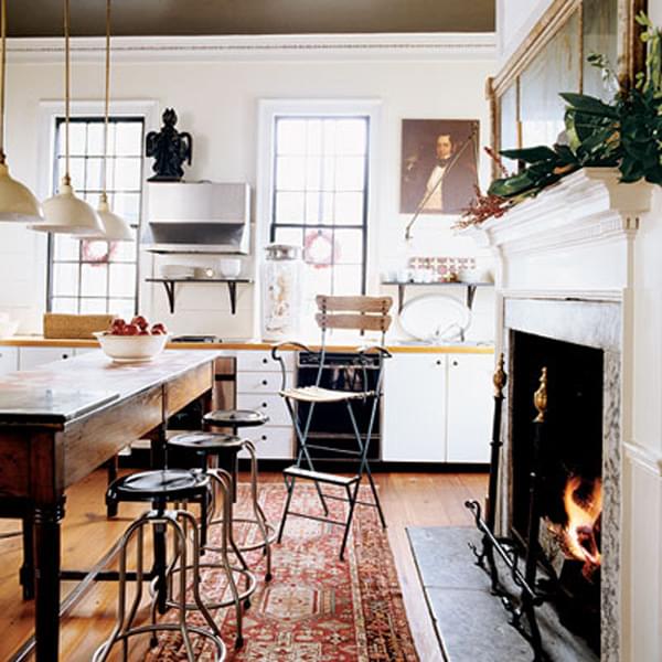 A beautiful rust antique Heriz lays in front of the kitchen fireplace. 