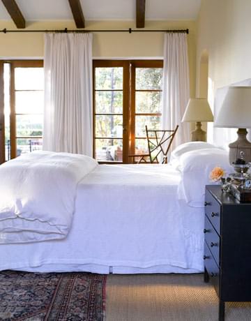 Design duo Dana Abbott and Kim Fiscus layer in a bedroom. Again the rug is the only pattern in the room.