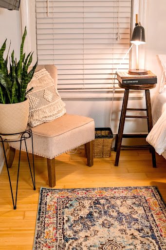 A worn persian rug in need of repair through repiling in a bedroom.