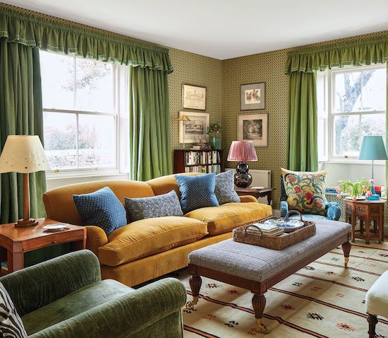 rita-konig-living-room-mustard-yellow-corduroy-sofa-green-curtains-ottoman-coffee-table-country-house-england-farmhouse-elle-decor-june-2019